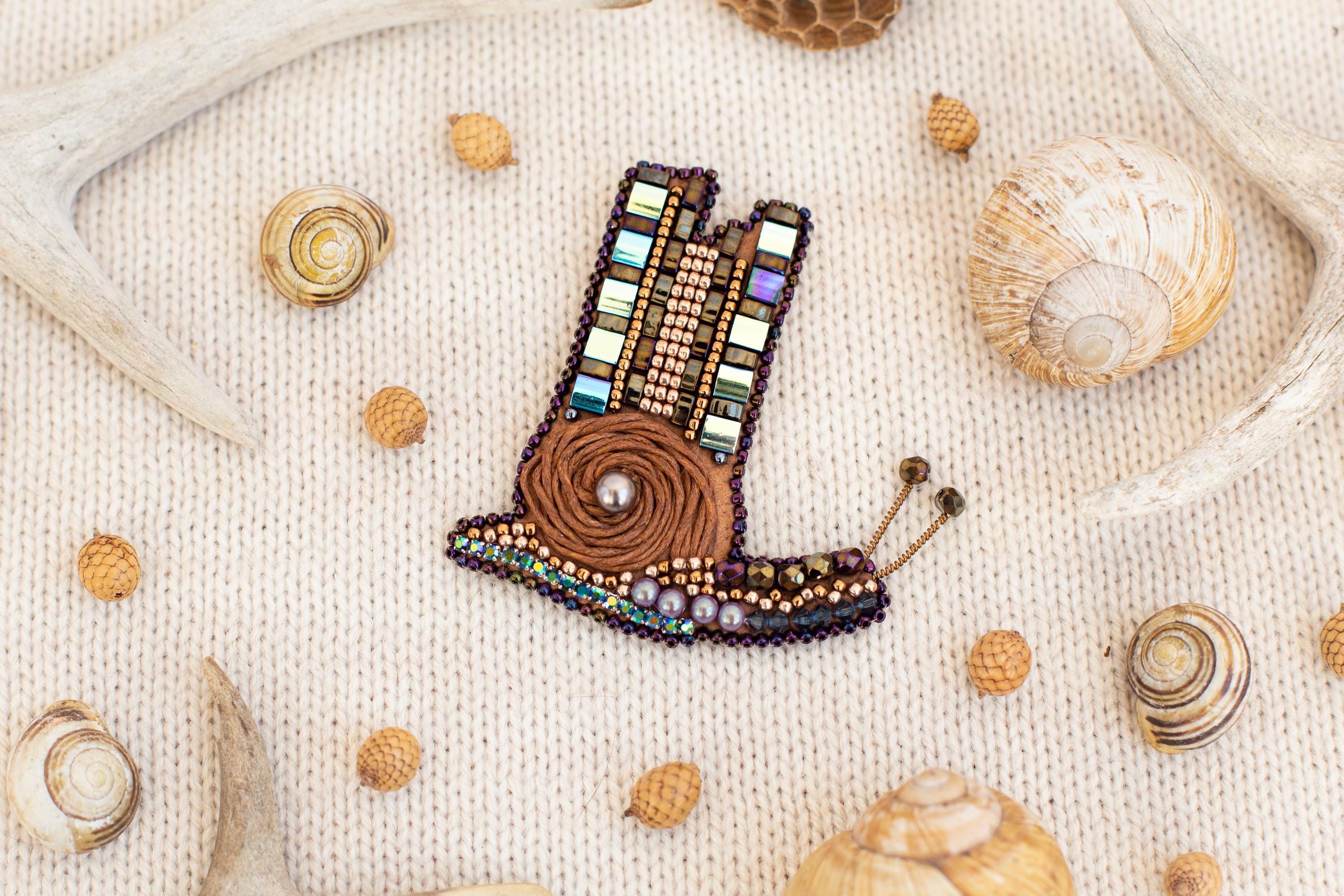 a picture of a beaded brooch with shells and seashells